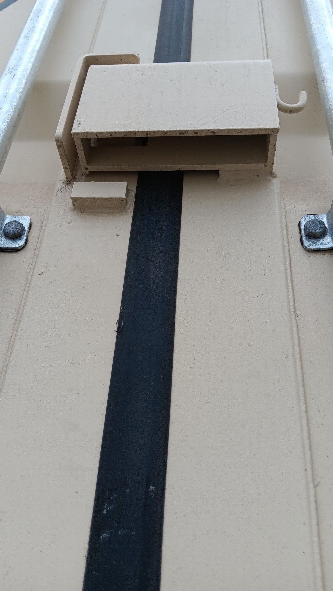 Tan and black metal structure with a locking mechanism.