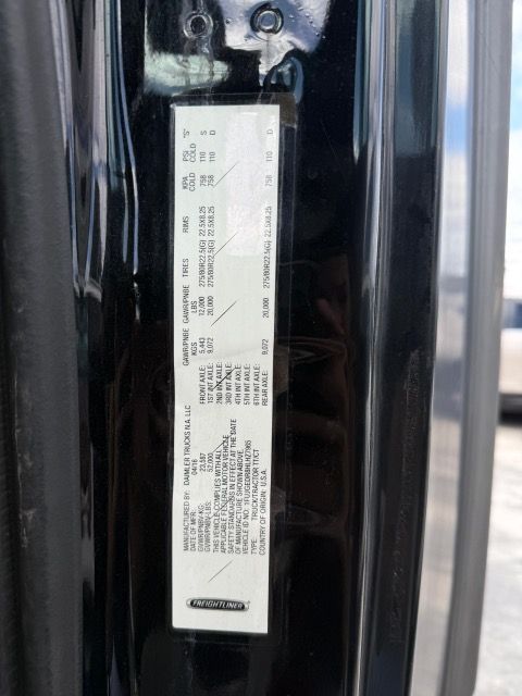 Vehicle information sticker inside a black car door frame, displaying codes and details.