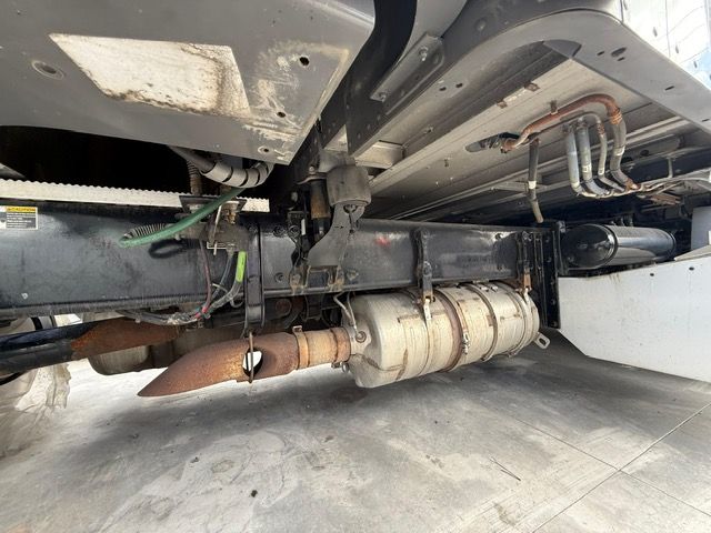 Underside of a semi-truck chassis. Exhaust pipe and various mechanical components are visible.