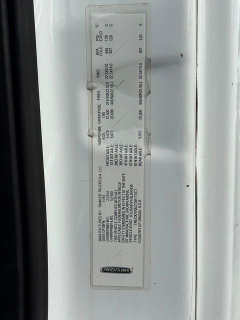 Vehicle information sticker affixed to a white door frame. The sticker is filled with black text on a white background.