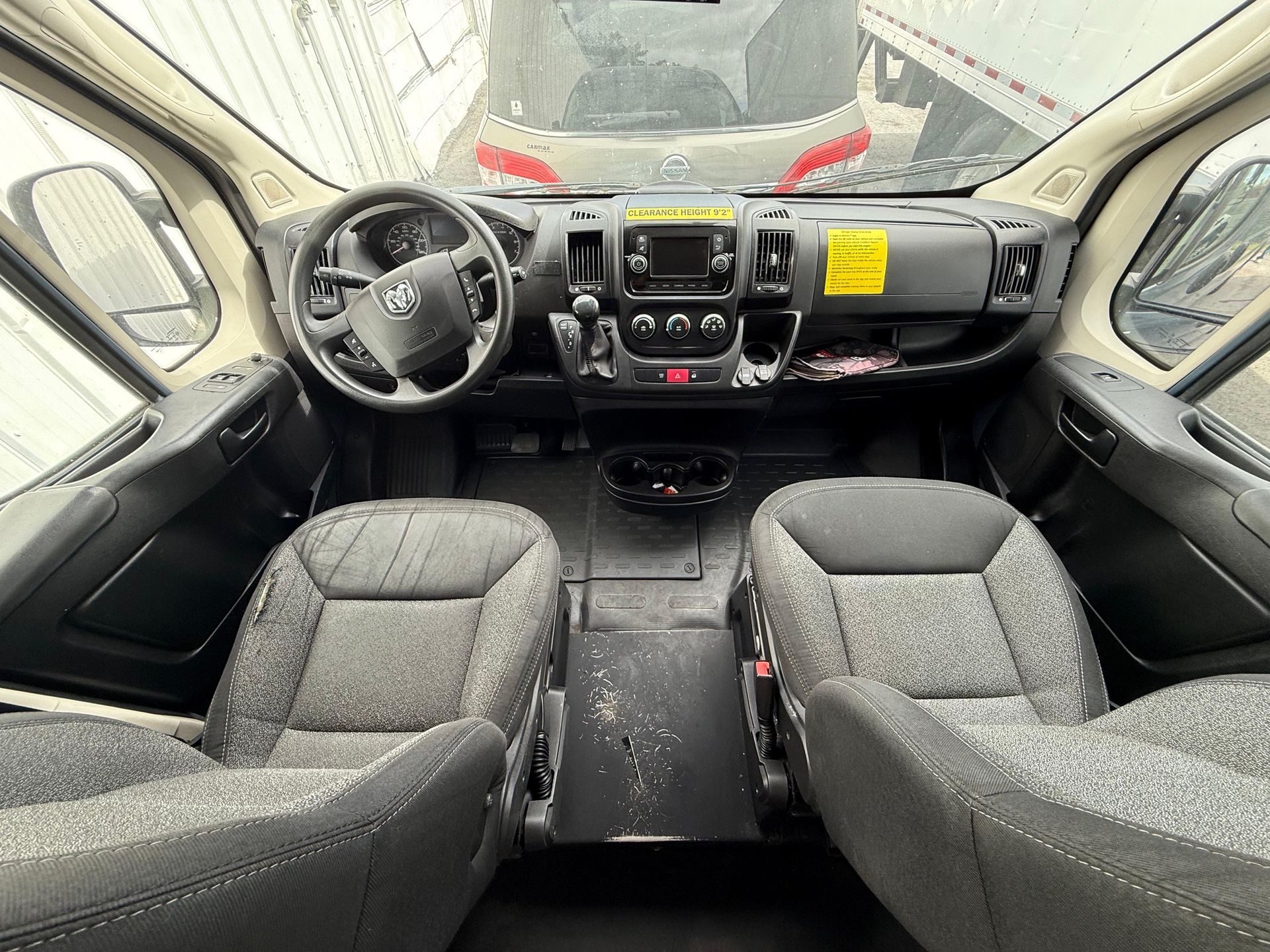 Interior view of a Ram ProMaster van's cockpit, showing the dashboard, steering wheel, and two front seats.