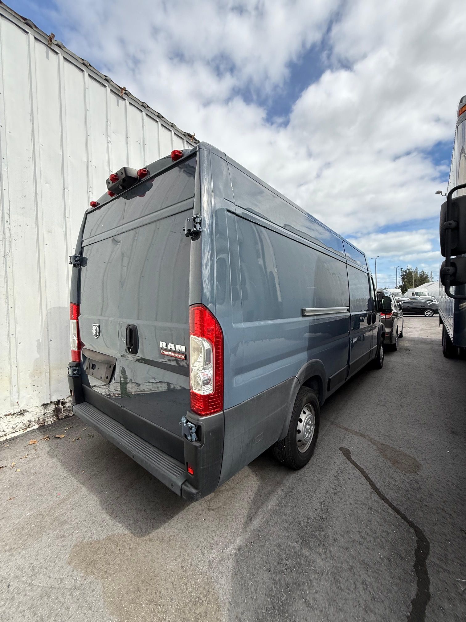 Gray Ram ProMaster van parked outdoors on a sunny day.