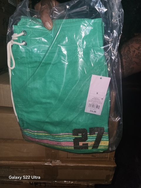 Green swim shorts in plastic packaging with 