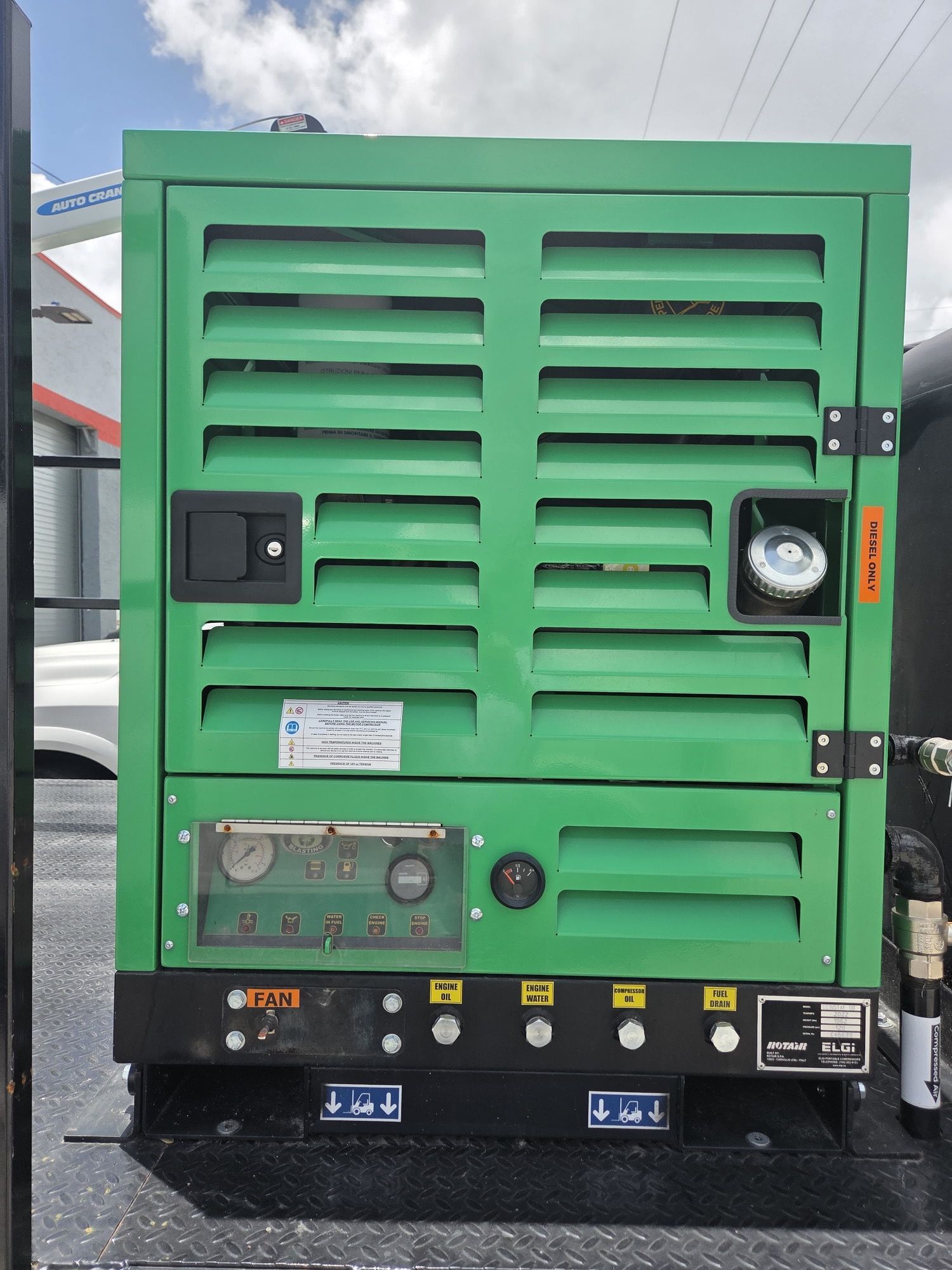 Green generator with ventilation, gauges, and fuel cap on a black base.