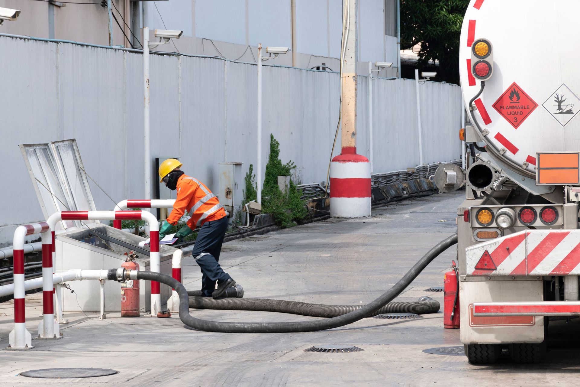 A man is pumping gas into a truck at a gas station.
