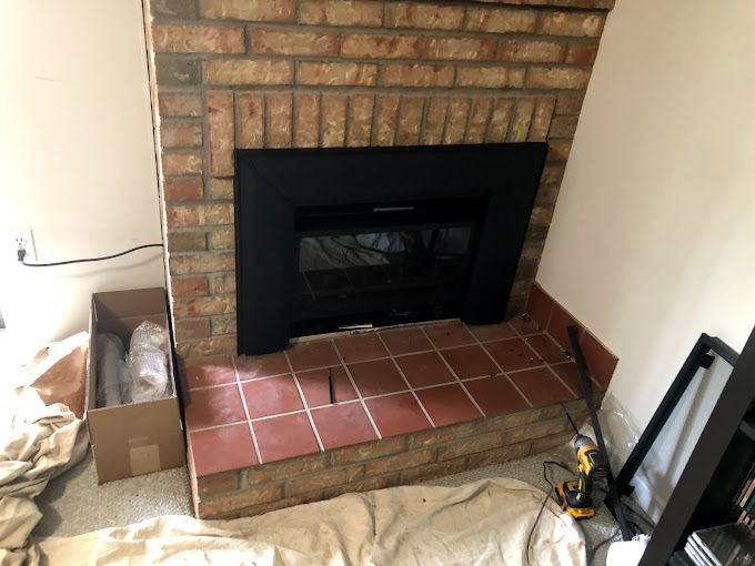A brick fireplace is being remodeled in a living room.
