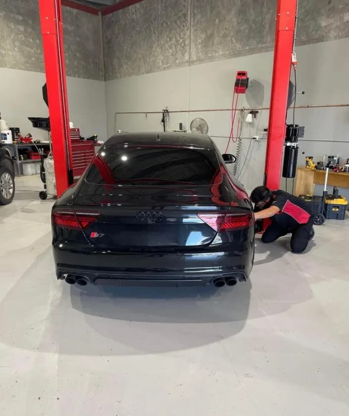 Black Audi Being Worked On By Mechanic In A Garage — MC Automotive Service & Repairs in Maitland, NSW