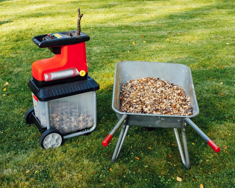 There Is a Wheelbarrow Filled with Leaves Next to A Shredder — Acres 2 Mow in Maitland, NSW