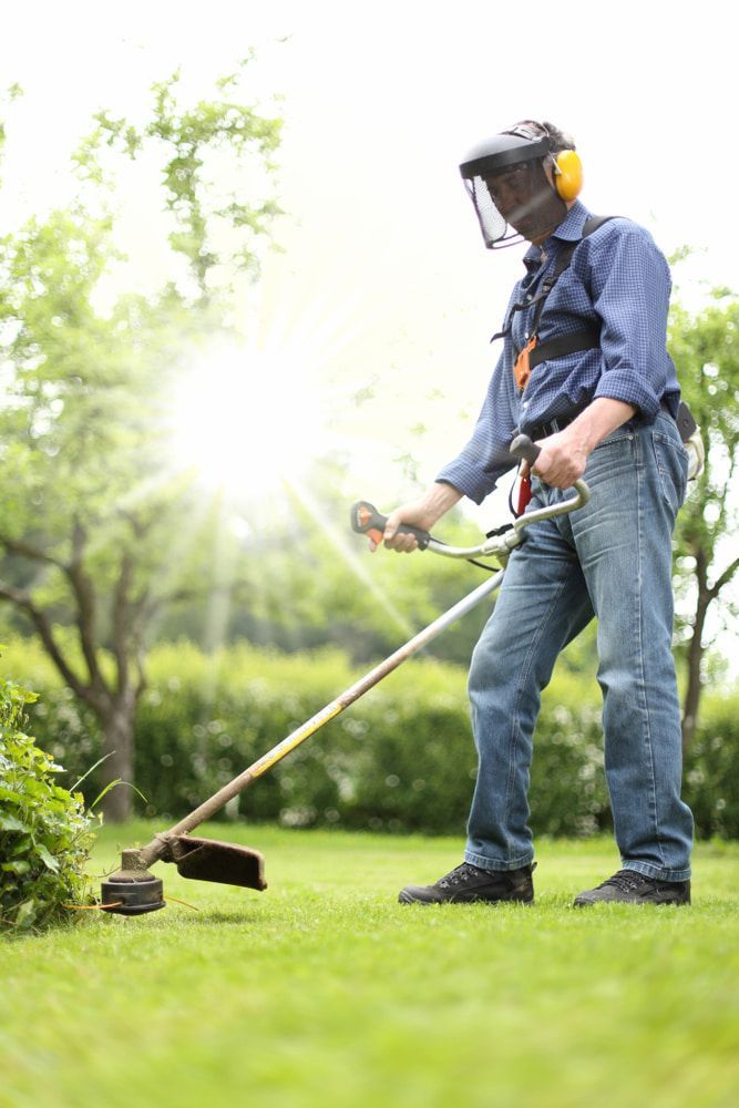 A Man Is Using a Lawn Mower to Cut the Grass in A Garden — Acres 2 Mow in Allandale, NSW