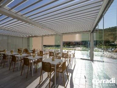 Ristorante con tavoli e sedie sotto un pergolato.