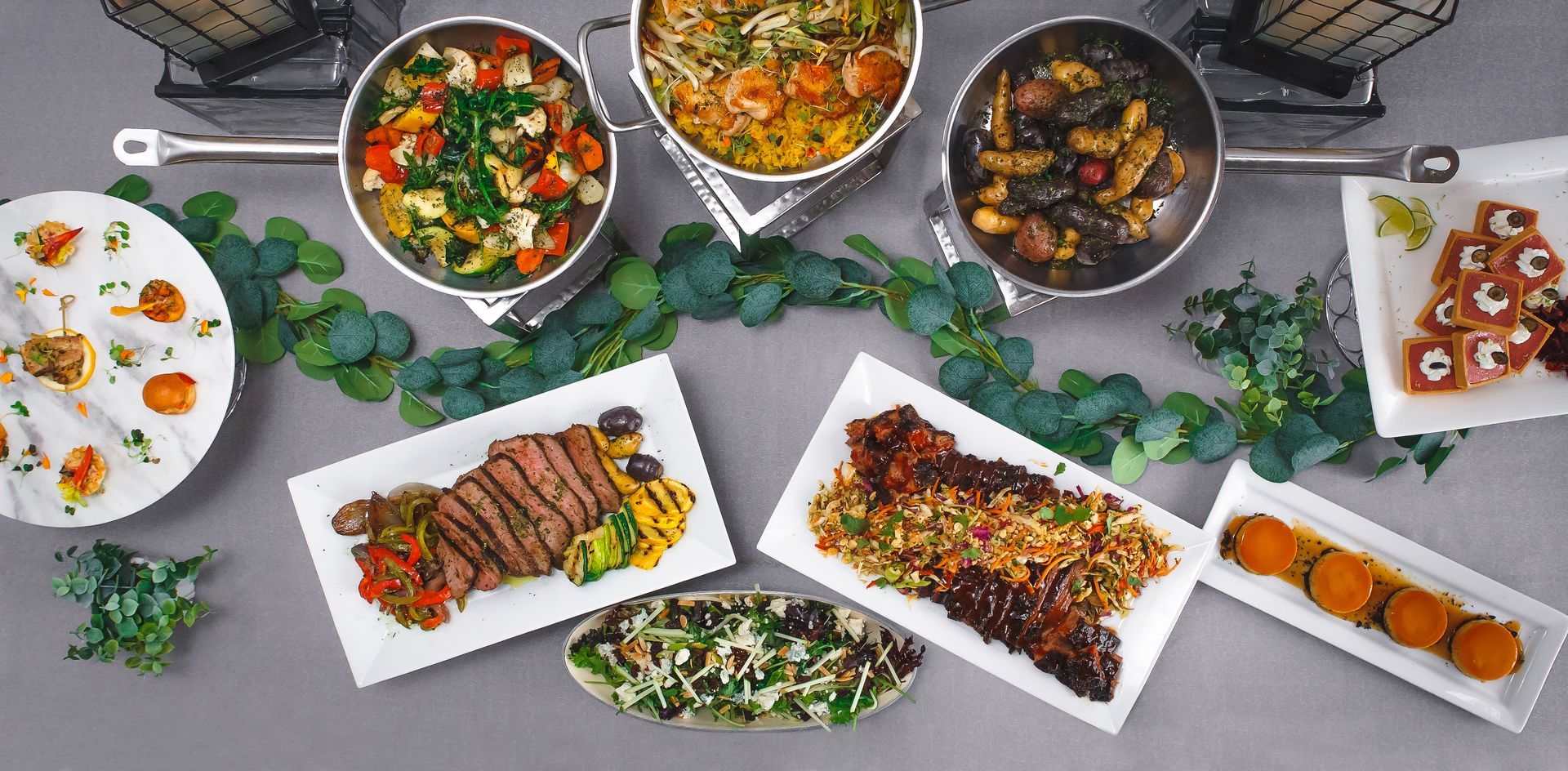 A table topped with plates of food and pots of food.