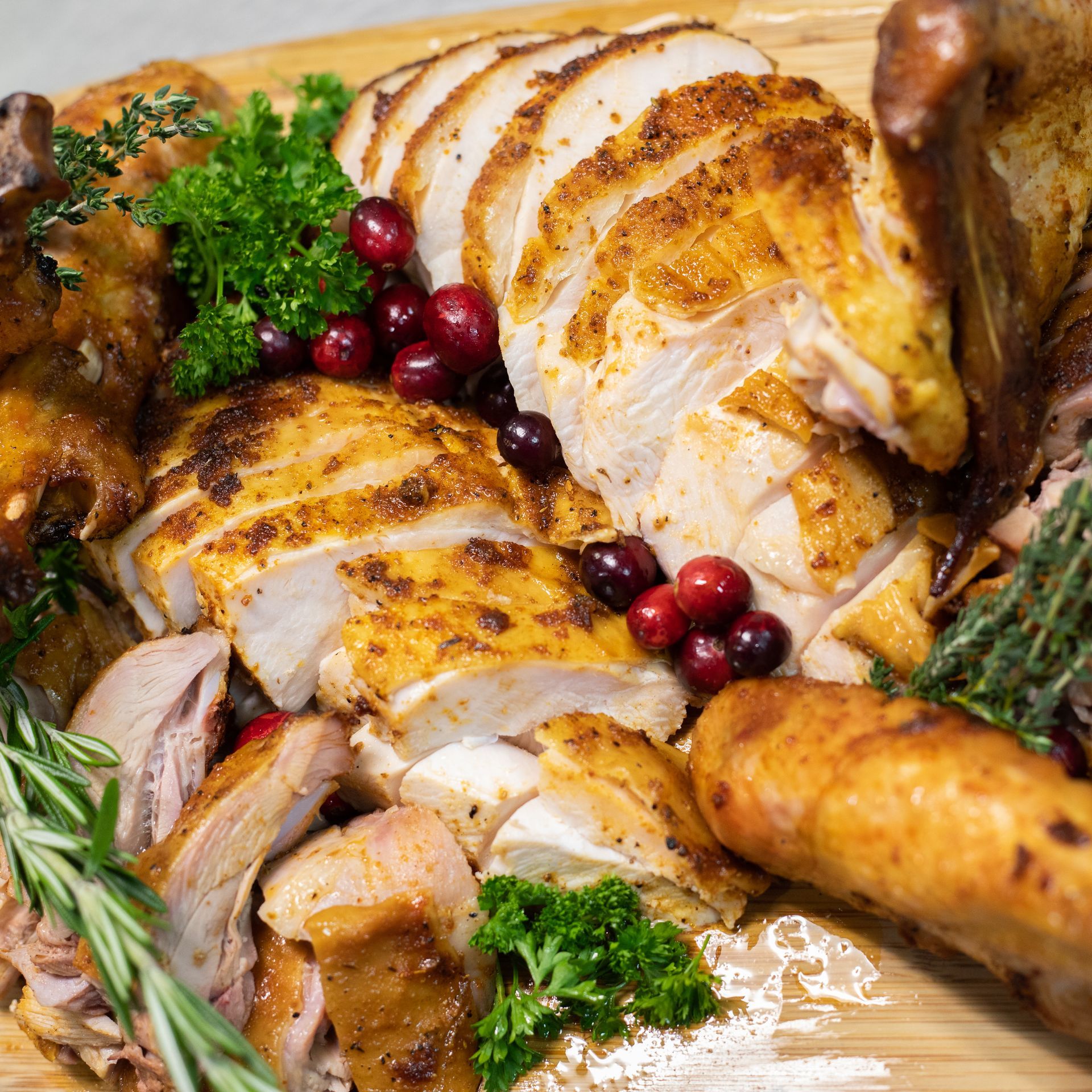 Sliced turkey with cranberries and parsley.