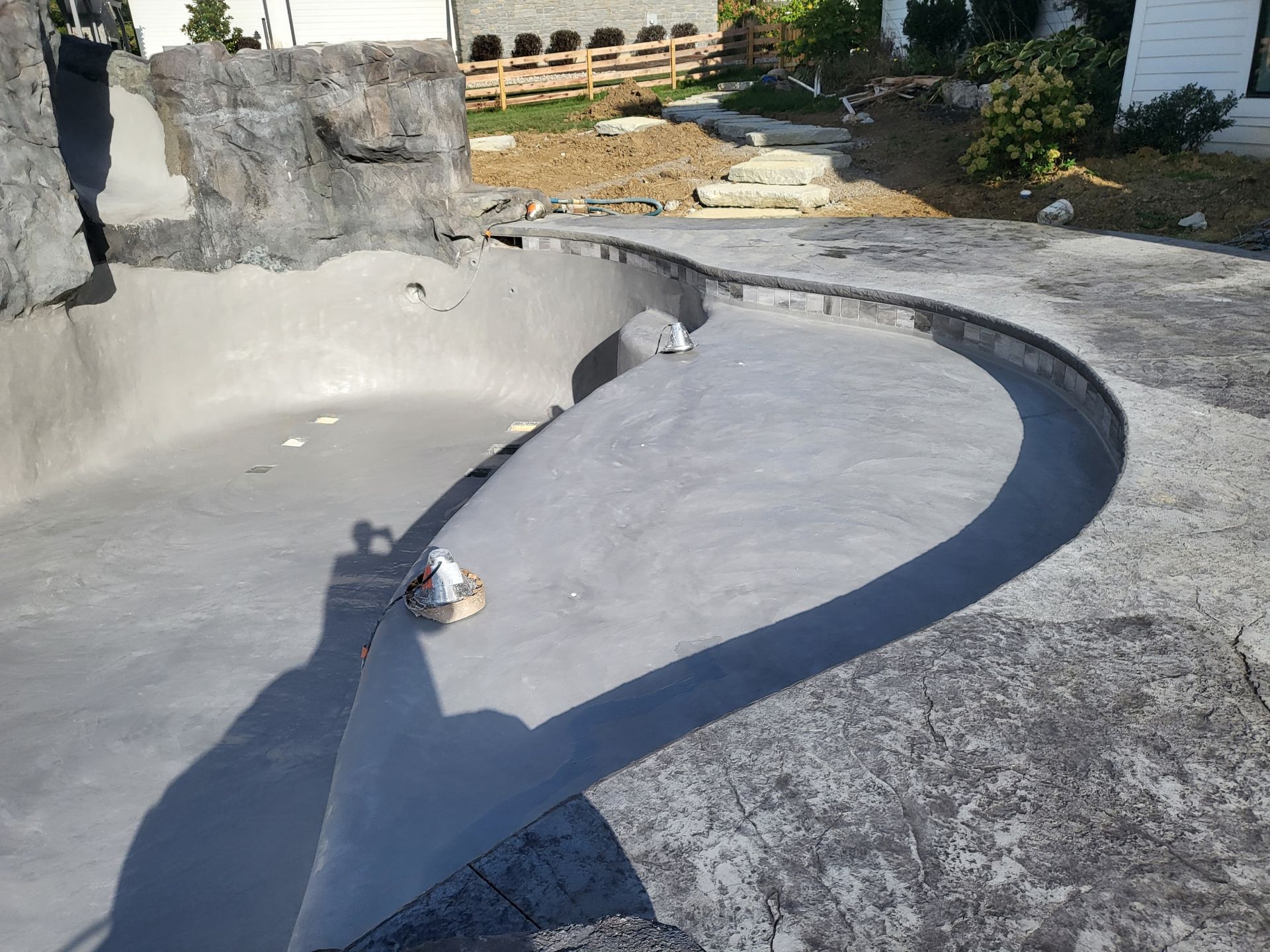 A shadow of a person is cast on a concrete surface
