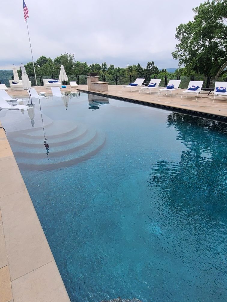 A large swimming pool with chairs and umbrellas around it