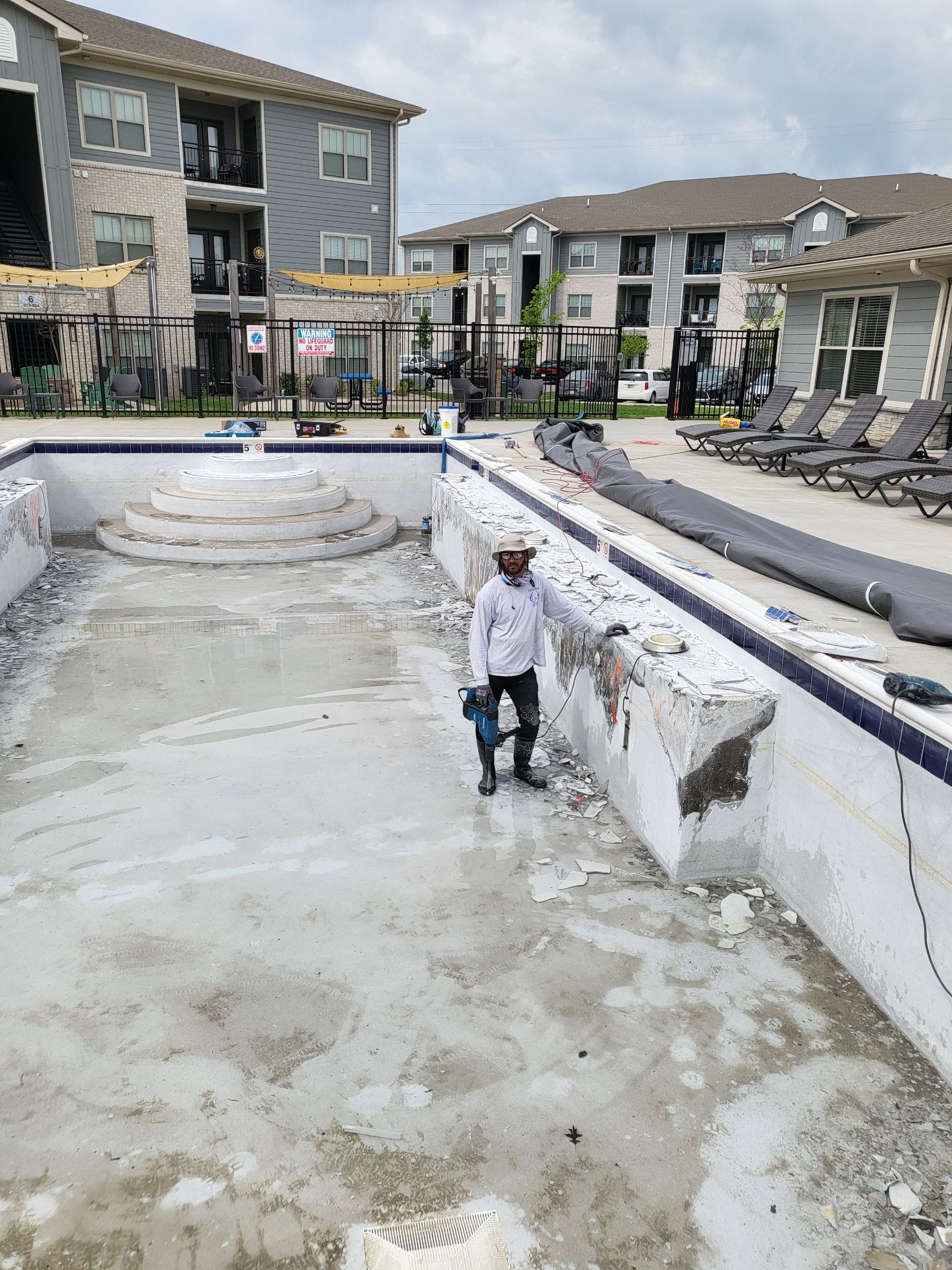 A man is standing in the middle of an empty swimming pool.