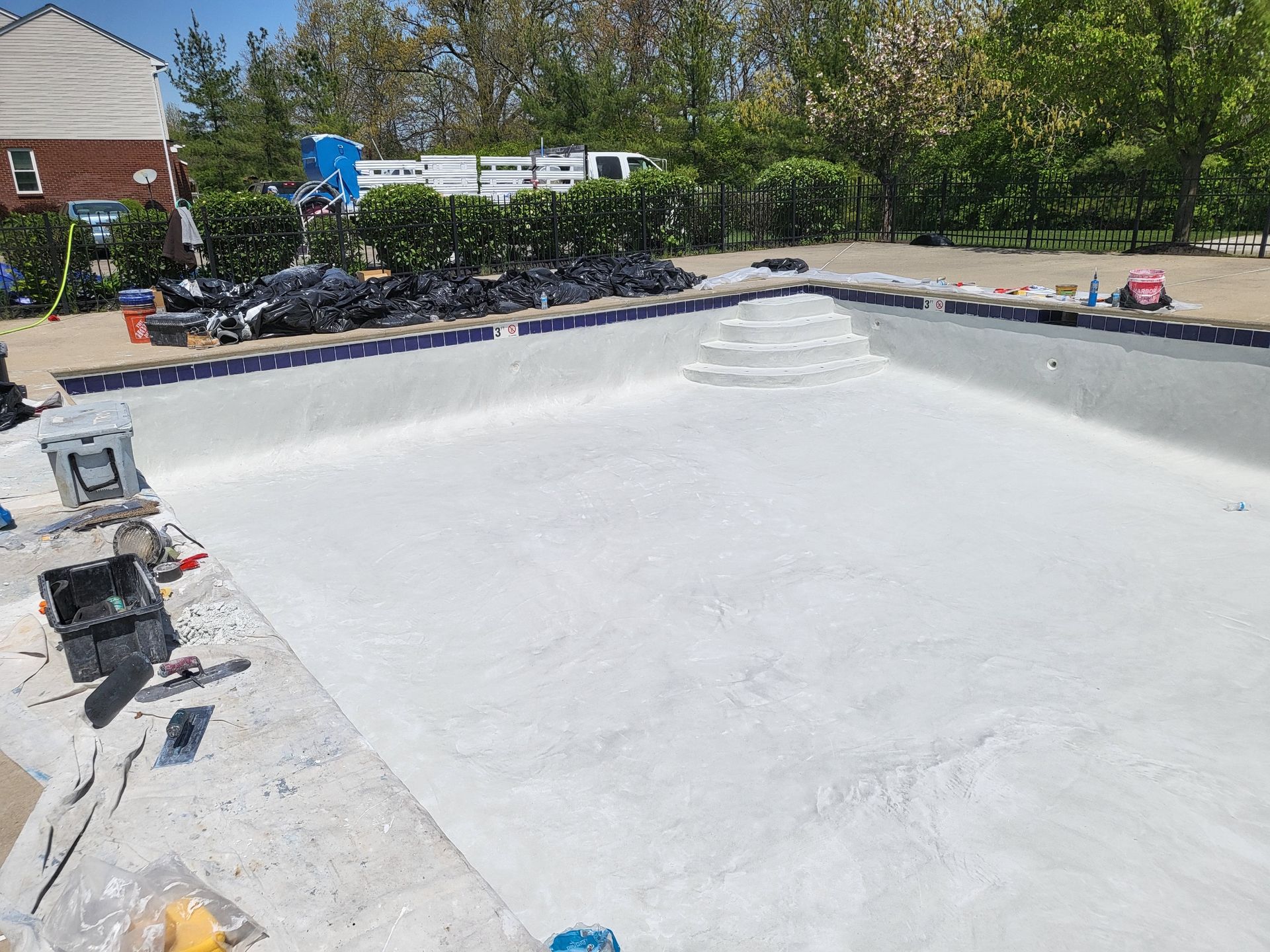 A large swimming pool is being built in a backyard.