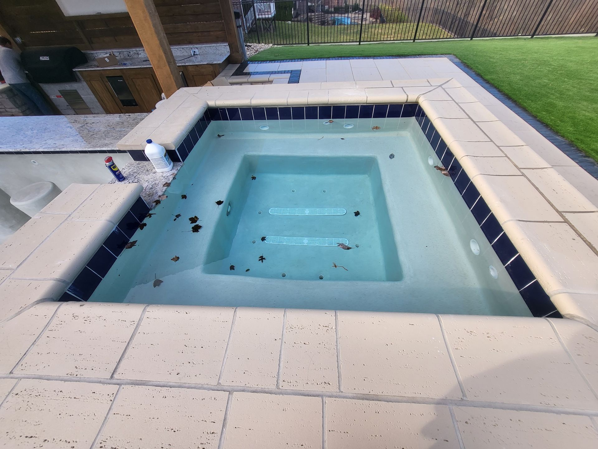 A swimming pool with a fence in the background