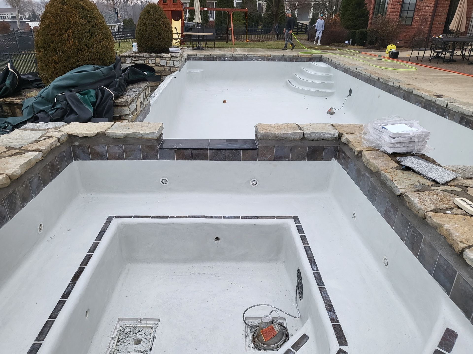 An empty swimming pool with a jacuzzi in the middle of it.