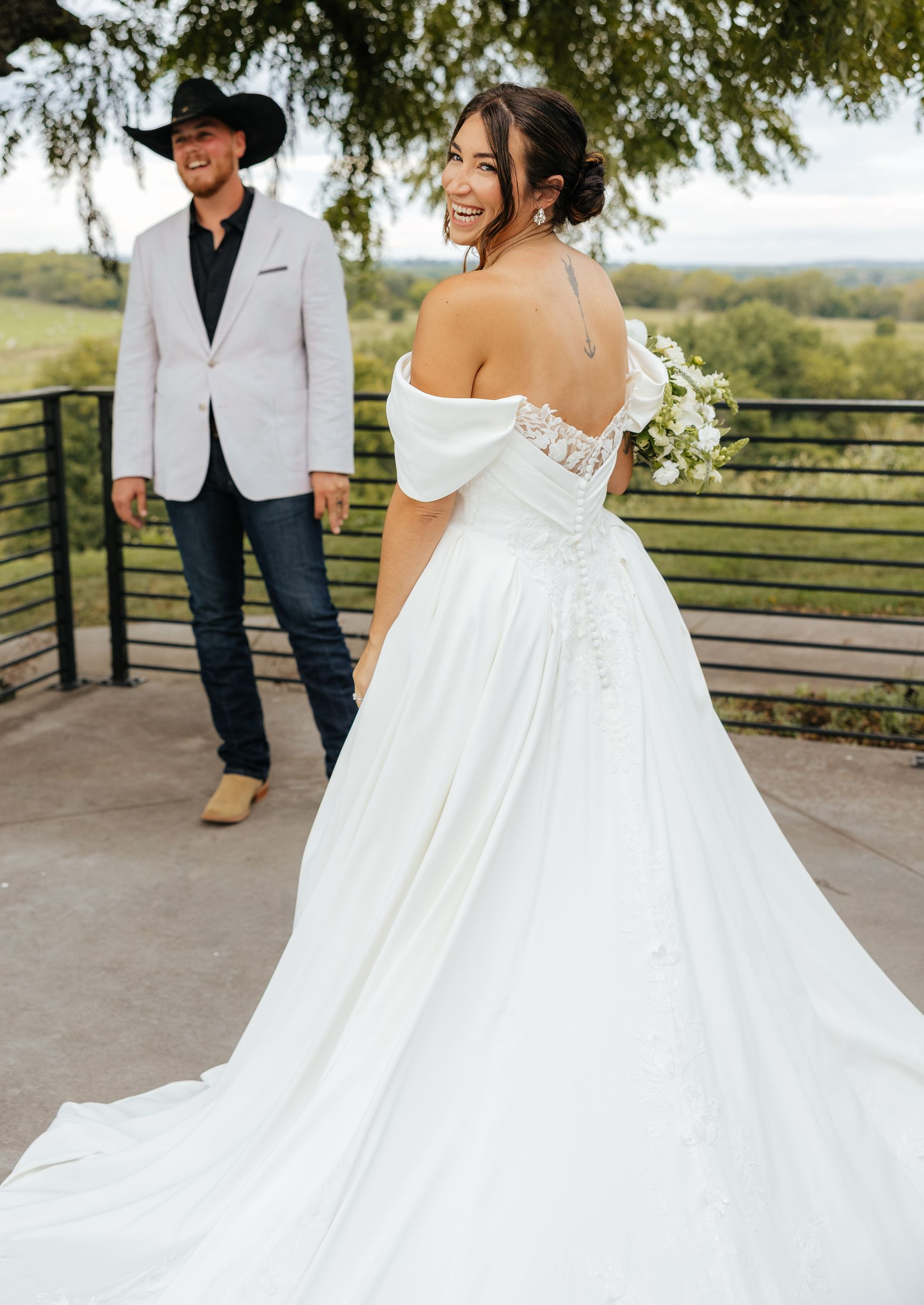 A bride in a wedding dress is standing on a set of stairs holding a bouquet of flowers.