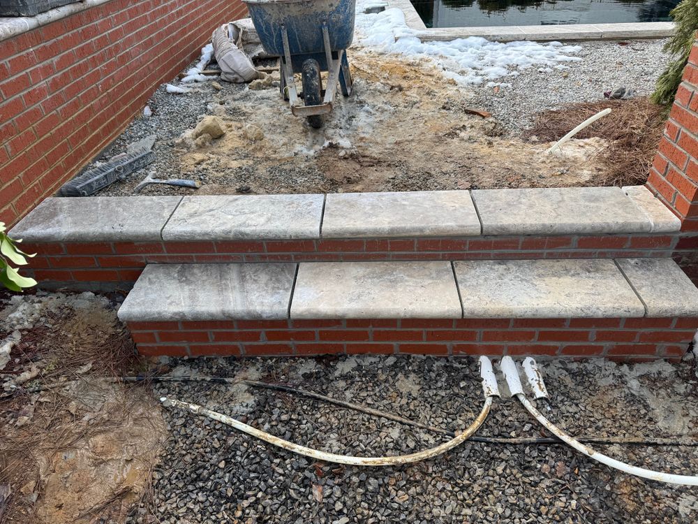 Brick steps leading to a muddy construction area with workers and exposed cables