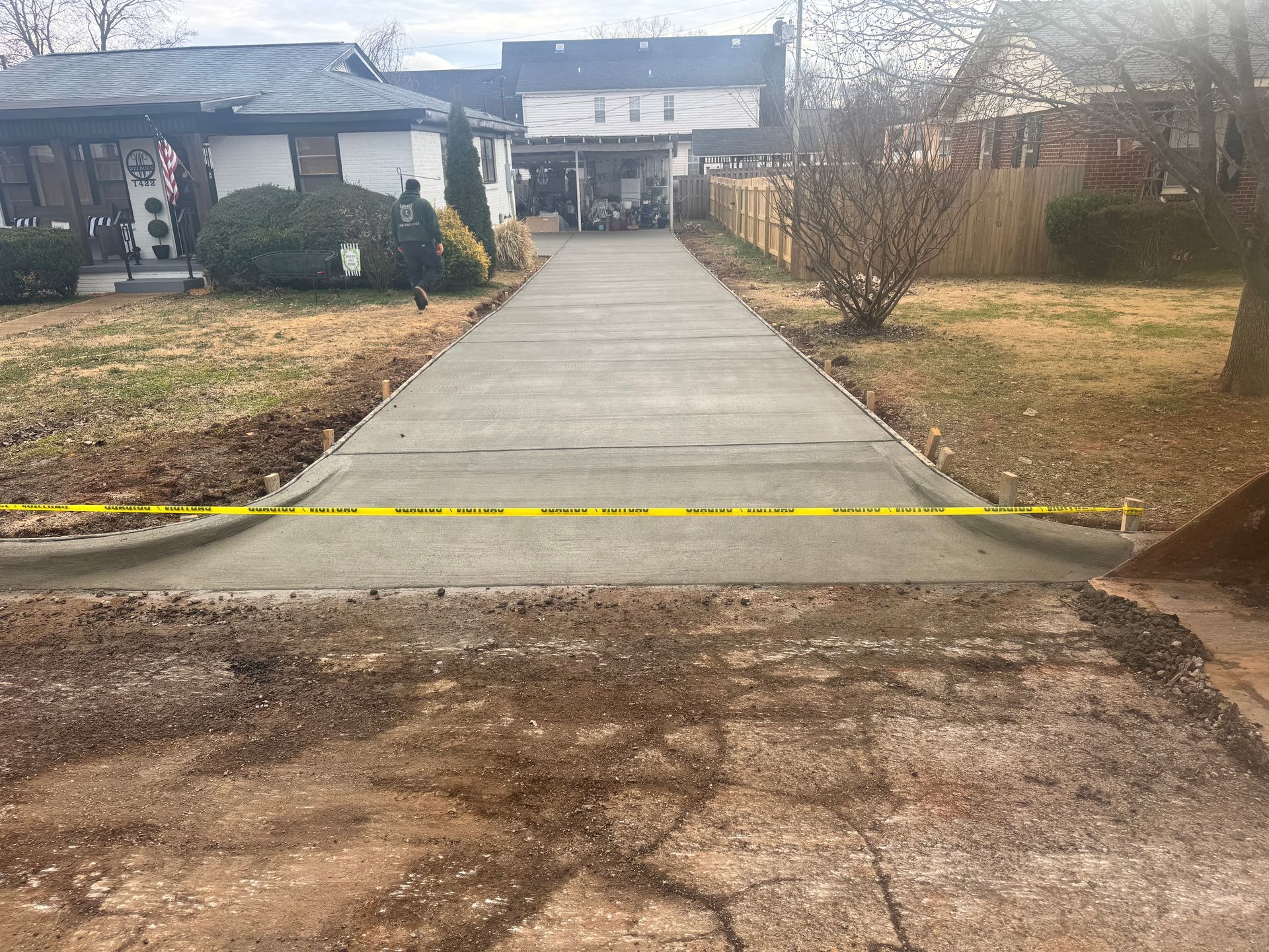 Rock-lined drainage culvert opening in a landscaped yard with gravel paths and grass