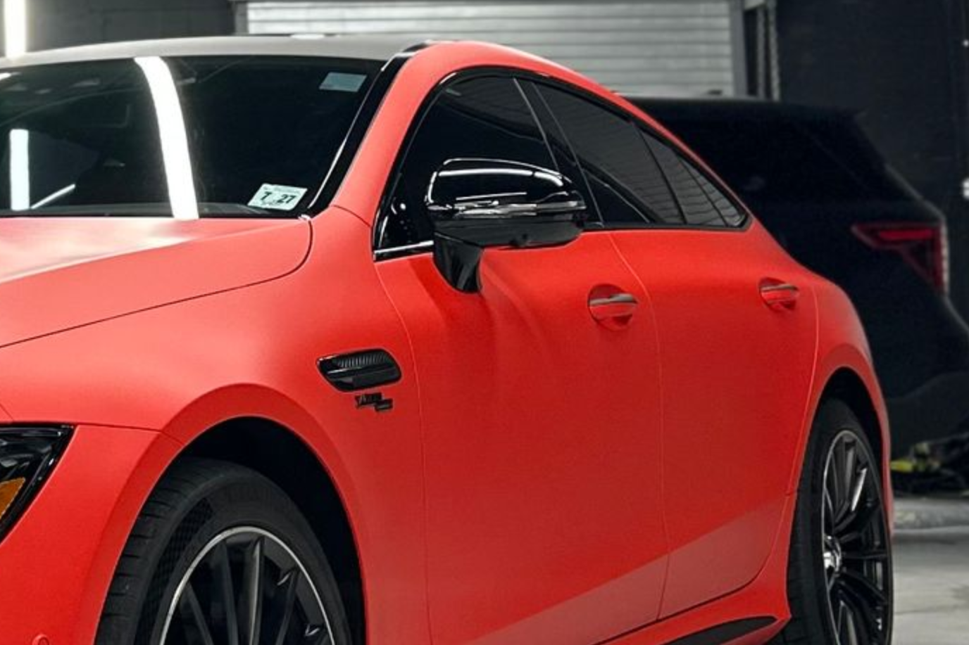 Red sports car with black accents parked inside.