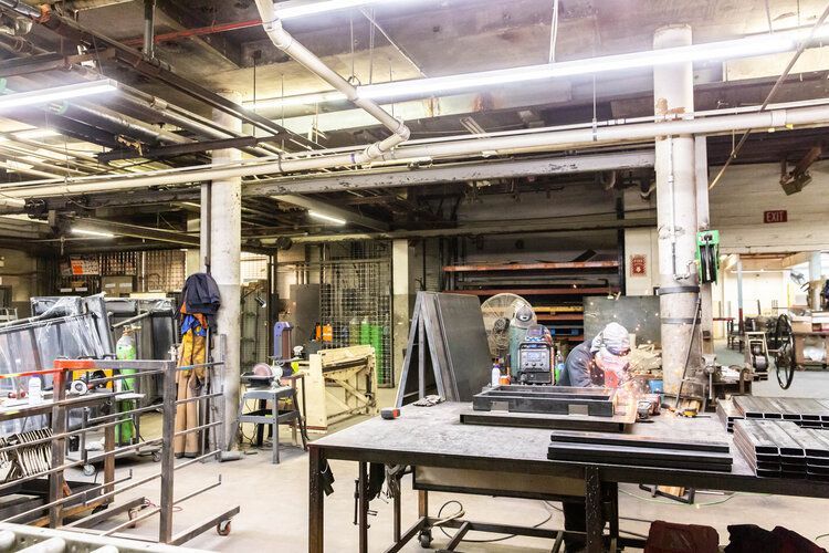 A man is working on a piece of metal in a factory.