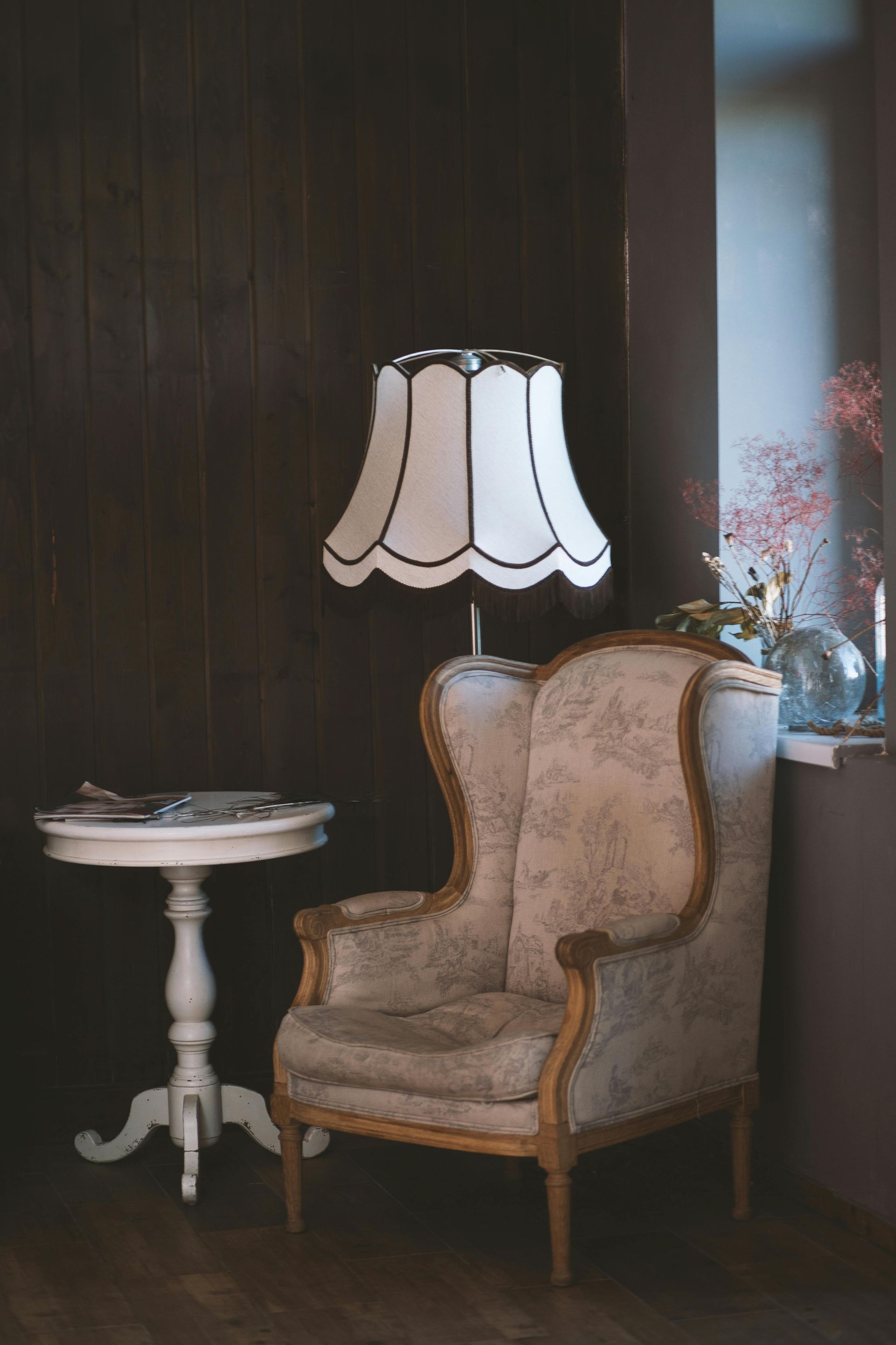 There is a chair and a lamp in the room.