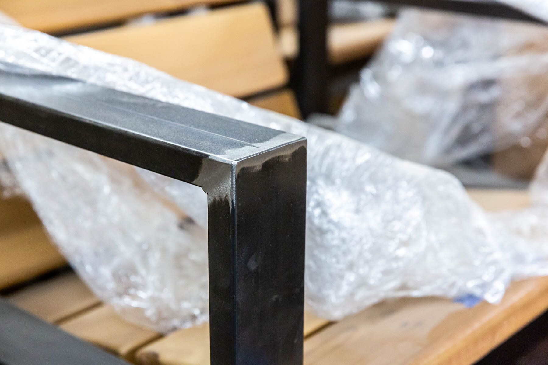 A close up of a metal frame on a wooden bench.