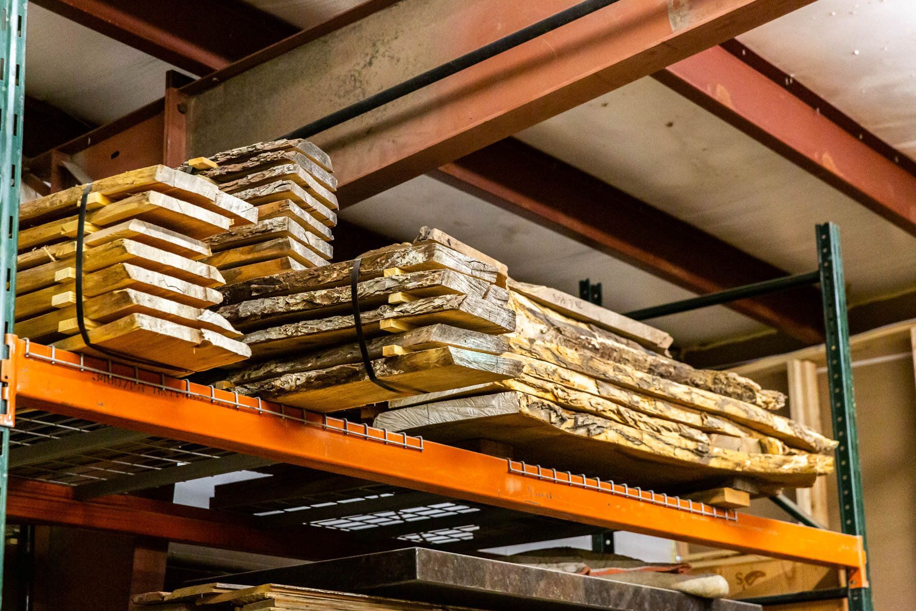 A warehouse filled with lots of wooden boards on shelves.