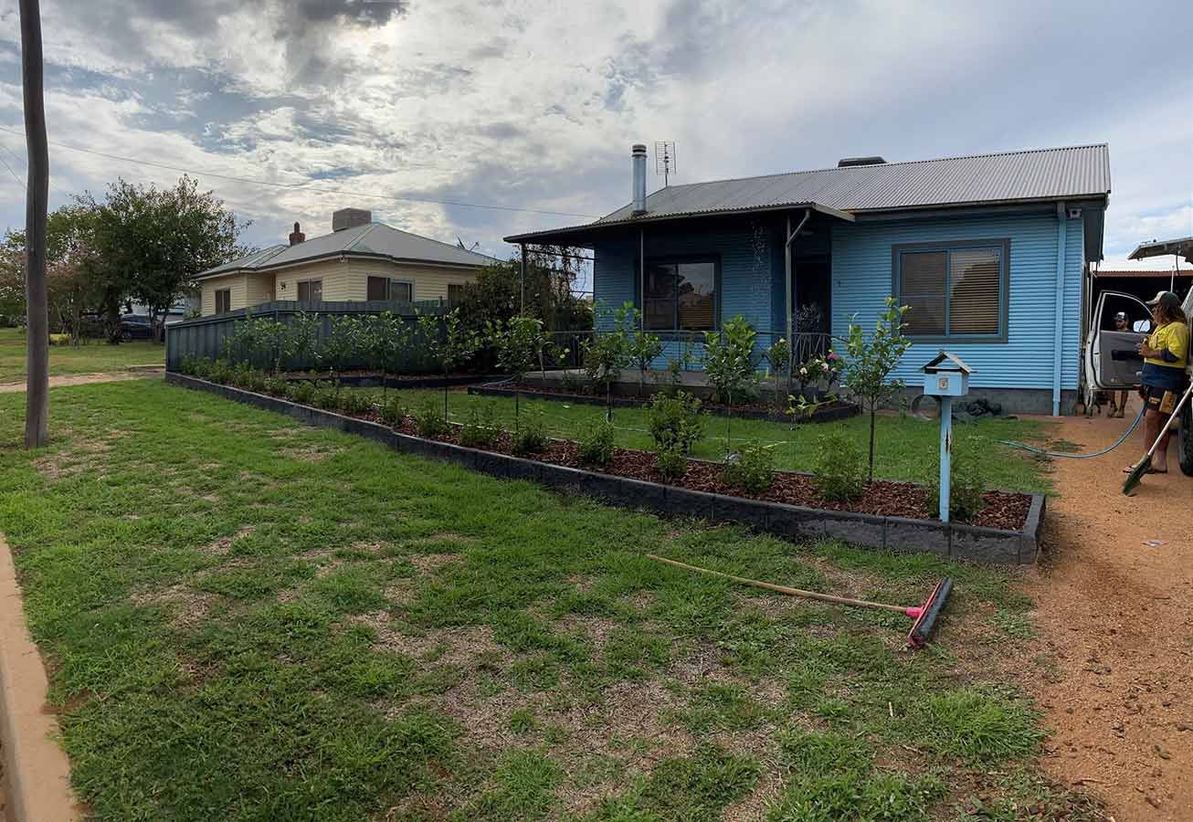 A Blue House With a Lot of Plants in Front of It — B & C Yard Improvements in Coonamble, NSW