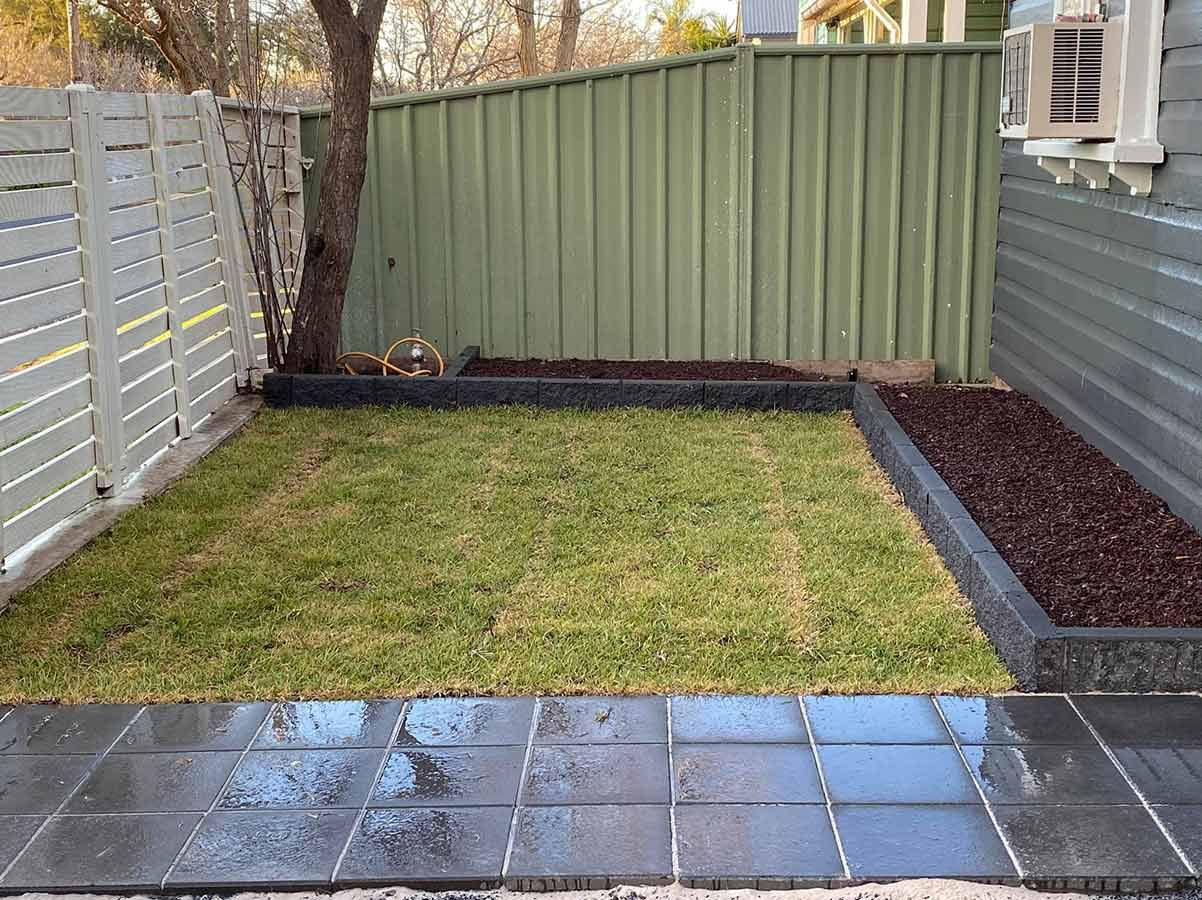 A Backyard With a Fence and a Lush Green Lawn — B & C Yard Improvements in Naroomine, NSW