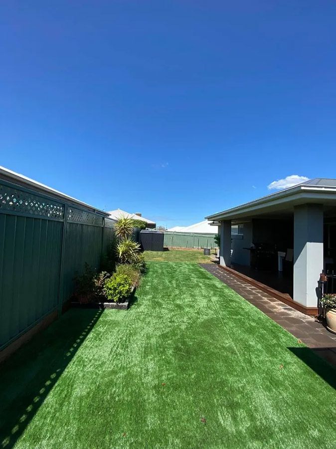 A Backyard With a Lush Green Lawn and a Fence — B & C Yard Improvements in Dubbo, NSW
