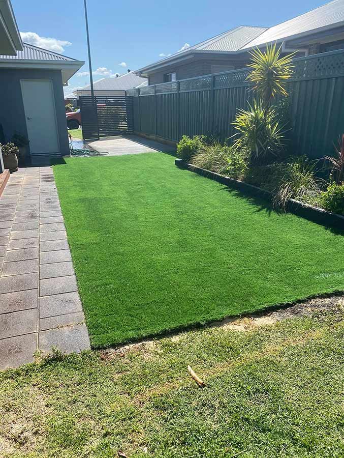 A Backyard With a Lush Green Lawn and a Fence — B & C Yard Improvements in Forbes, NSW
