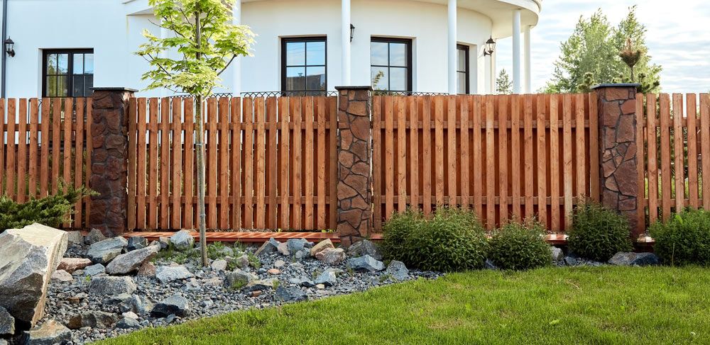 A Wooden Fence is in Front of a Large White House — B & C Yard Improvements in Warren, NSW