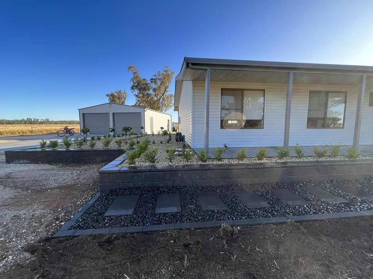 A White House With a Porch and a Brick Wall in Front of It — B & C Yard Improvements in Dubbo, NSW