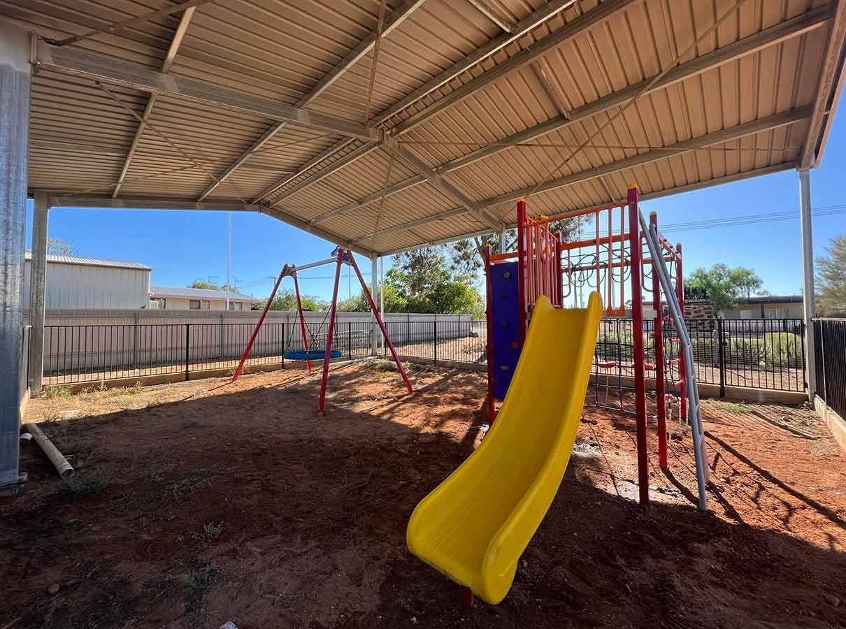A Yellow Slide is in a Playground Under a Canopy — B & C Yard Improvements in Dubbo, NSW