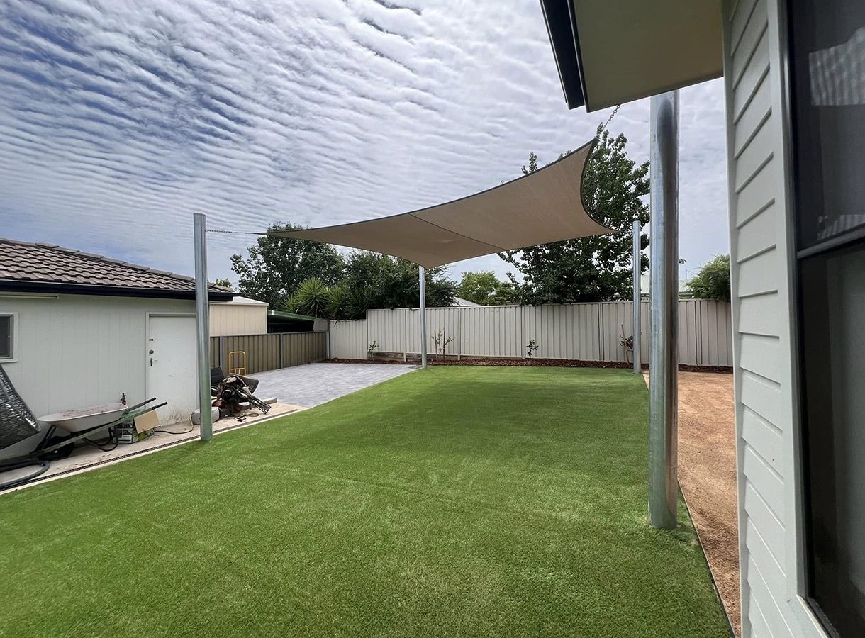 A Backyard With a Large Lawn and a Shade Sail — B & C Yard Improvements in Orange, NSW
