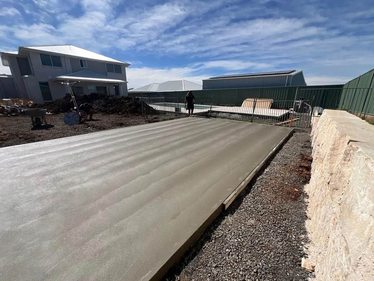 A Concrete Driveway is Being Built in Front of a House — B & C Yard Improvements in Dubbo, NSW