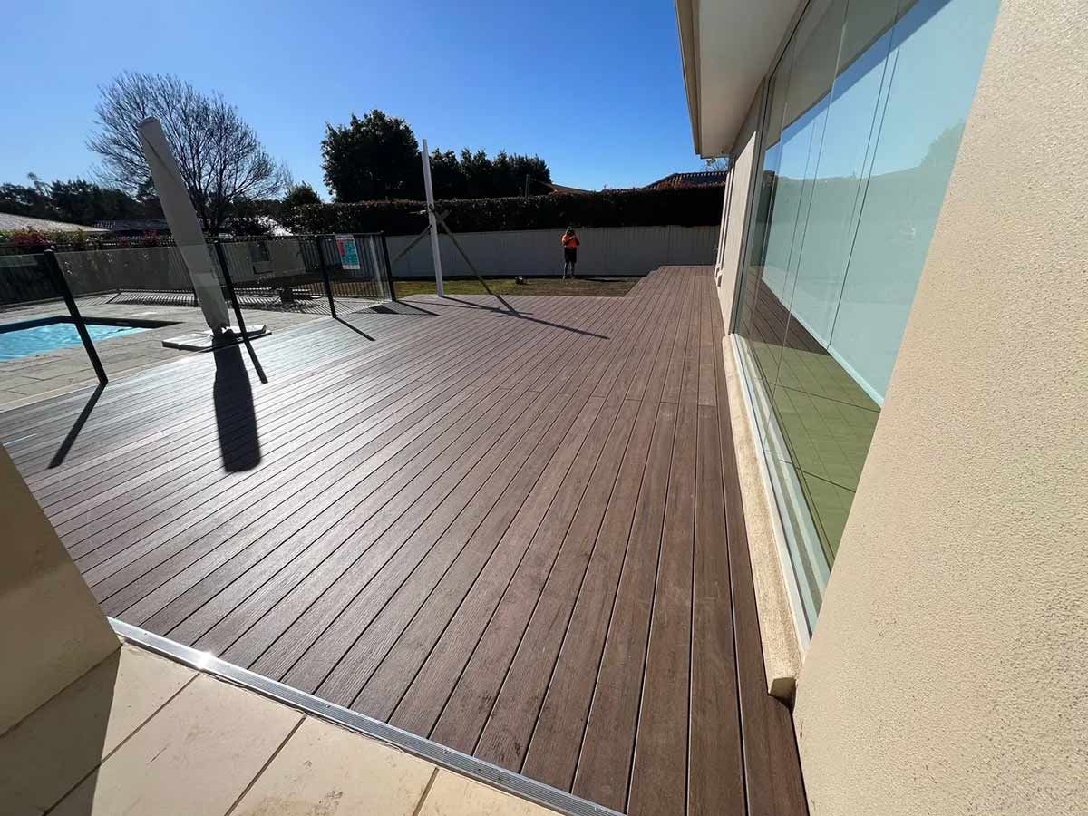 A Large Wooden Deck With a Swimming Pool in the Background — B & C Yard Improvements in Dubbo, NSW
