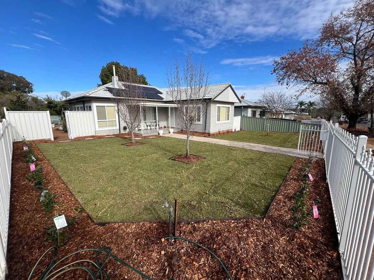 A White Fence Surrounds a Large Lawn in Front of a House — B & C Yard Improvements in Dubbo, NSW