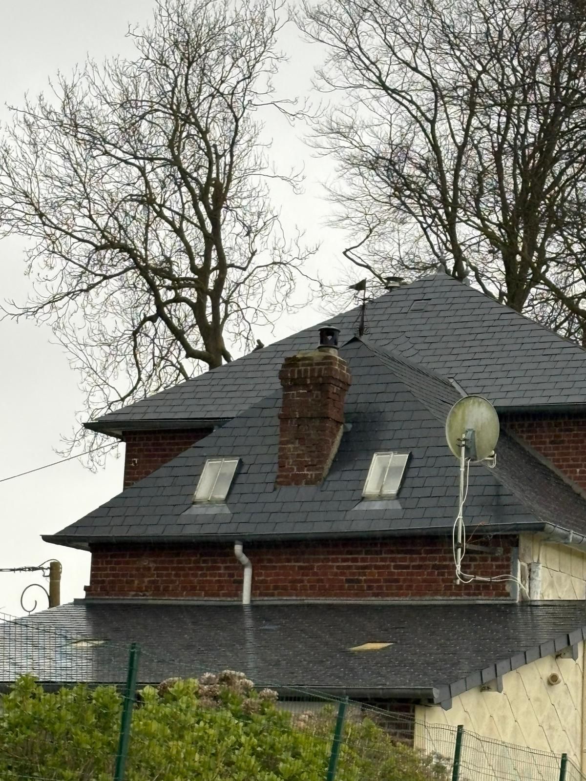 démoussage d'un toit avec de la mousse et des tâches sur une maison à Rouen, photo prise après