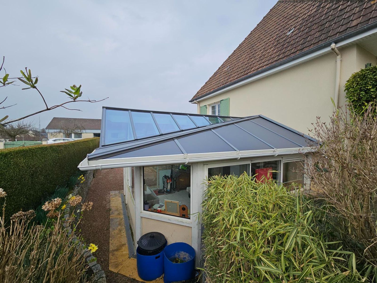 démoussage du toit d'une extension véranda de maison après