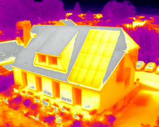 Image thermique d'une maison équipée de panneaux solaires, montrant la répartition de la chaleur
