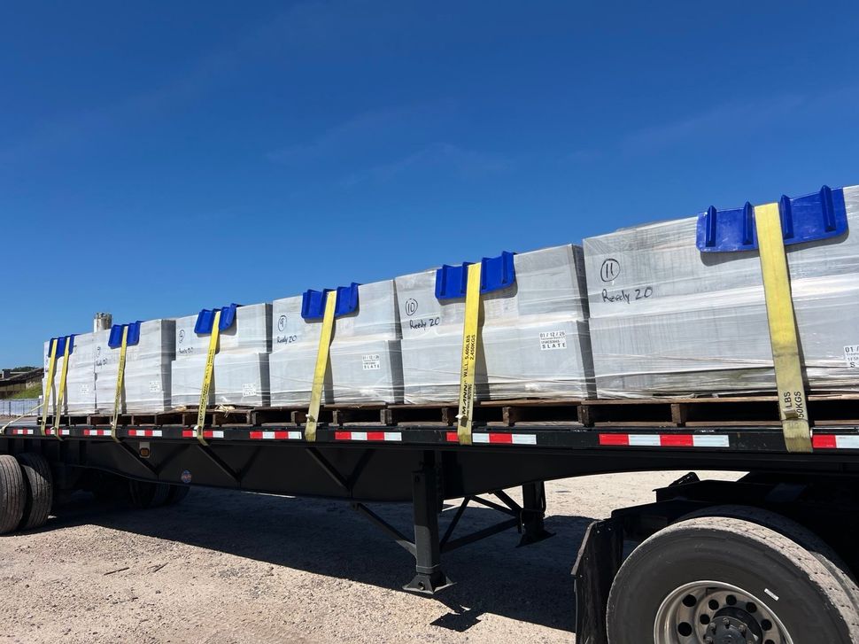 Flatbed truck loaded with pallets of roof tile at a job site