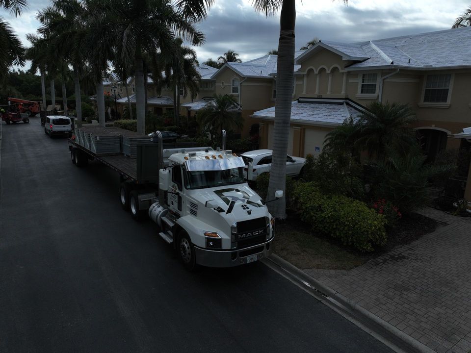 Flatbed truck loaded with roof tile pallets at a job site