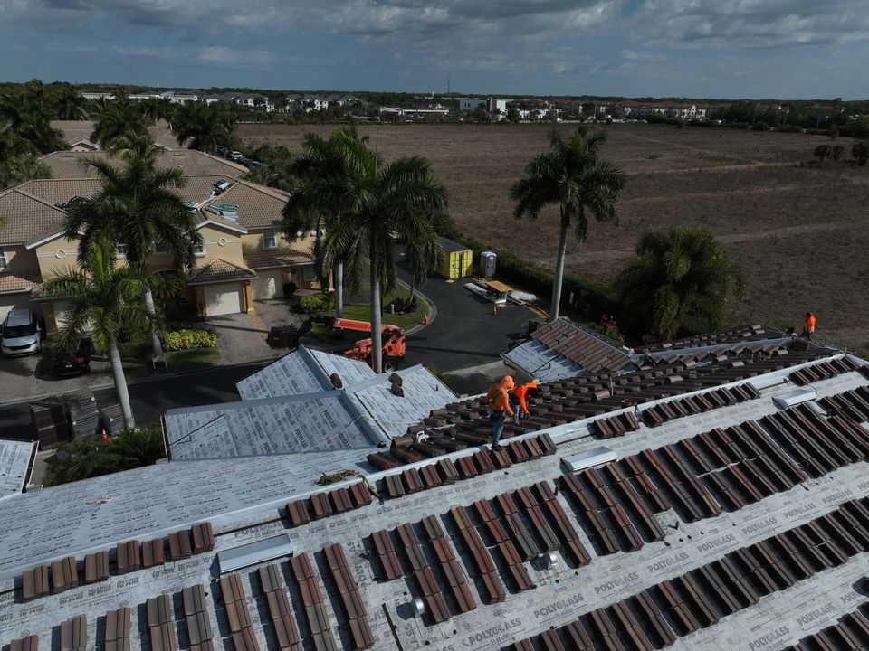 Workers loading roof tile onto a residential roof deck