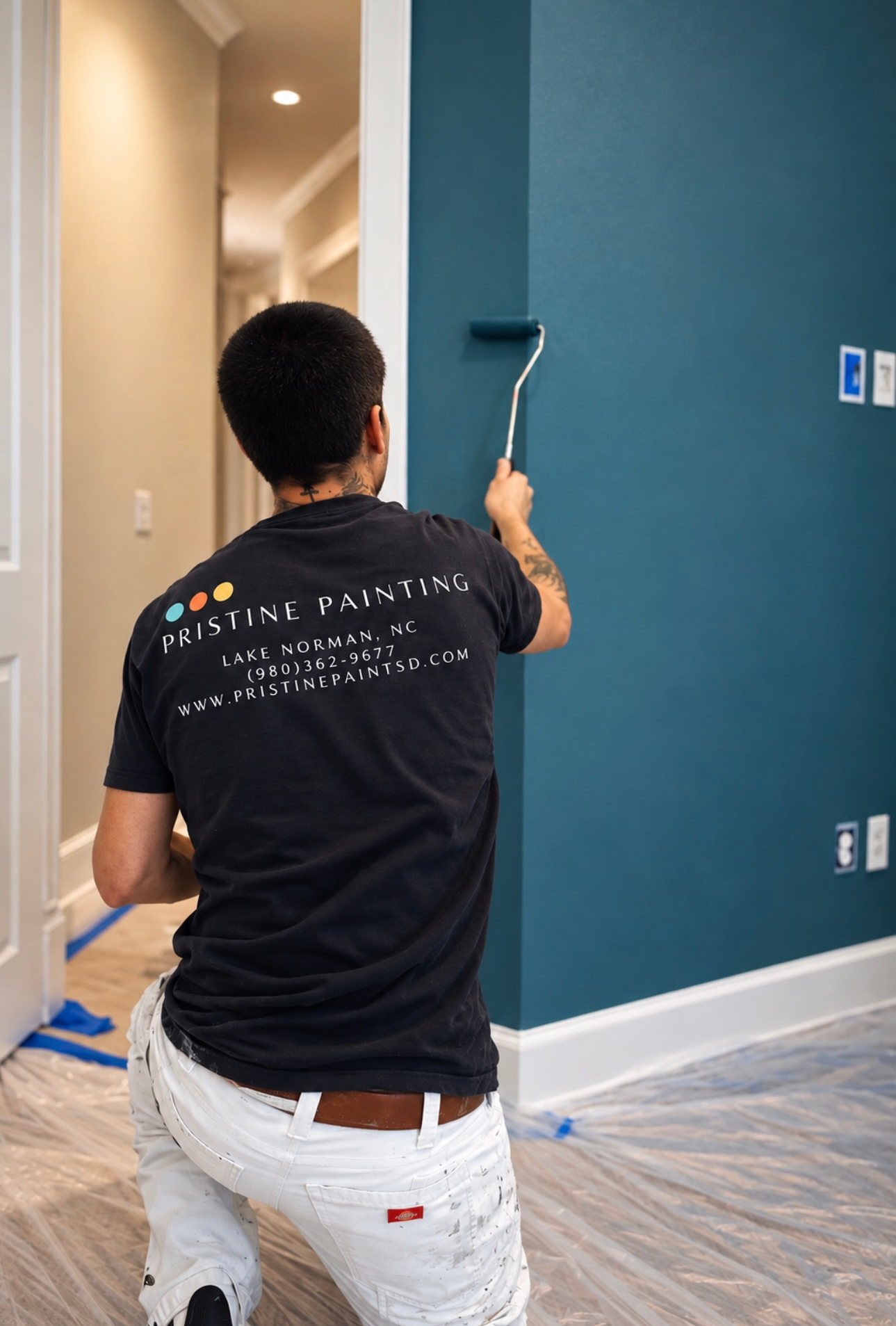 Painter rolling blue paint on a wall in a room under renovation