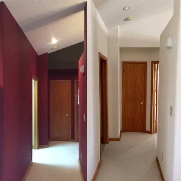 Hallway with burgundy and white walls, carpeted floor, and closed wooden doors at the end.