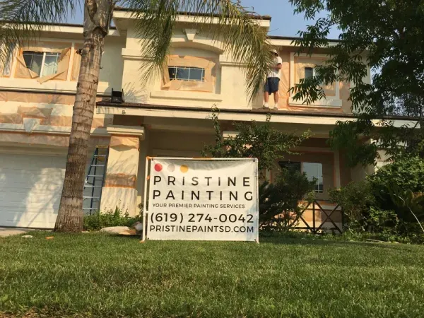 Pristine Painting yard sign in front of a beige house, with contact info visible.